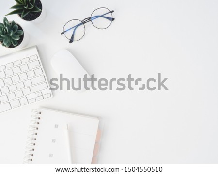 top view of office desk table with notebook, plastic plant, digital camera and keyboard on white background, graphic designer, Creative Designer concept.