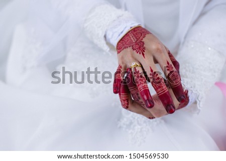 Wedding ring on bride's finger with henna arts or tattoo