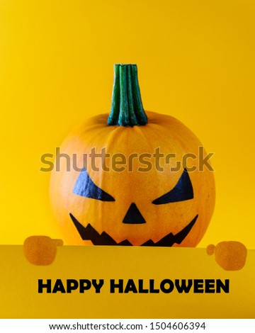Happy halloween. Pumpkin with the inscription in the hands on an orange background.