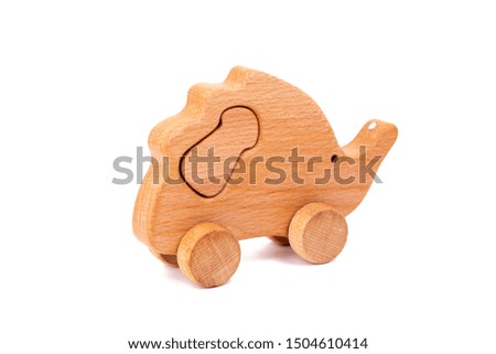 Photo of a wooden hedgehog with mushroom on wheels  of beech. Toy made of wood  on a white isolated background.A toy for entertaining children and resting parents