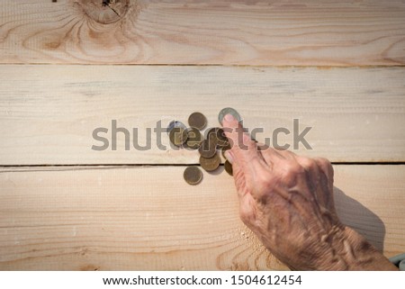 Hands of an elderly man holding coins. The concept of lack of money, the poor, the small pension of old people. Image. Royalty-Free Stock Photo #1504612454