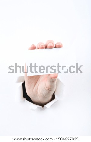 Hand holding blank card from white torn paper