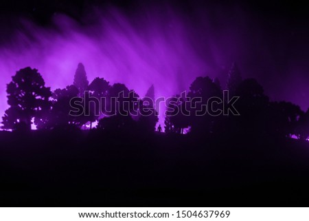 surreal light in dark forest and man silhouette. Horror Halloween concept. Table decoration