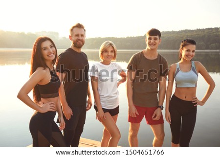 A group athletes are smiling in a city park
