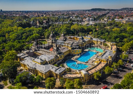 Budapest, Hungary - Aerial drone view of the famous Szechenyi Thermal Bath and Spa on a sunny summer day. Heroes' Square, Vajdahunyad Castle and Buda Hills at background. Royalty-Free Stock Photo #1504660892