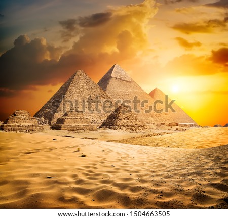 Egyptian pyramids in the desert at sunset Royalty-Free Stock Photo #1504663505