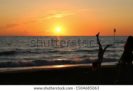 Italy, Tuscany region. People on the beach at sunset