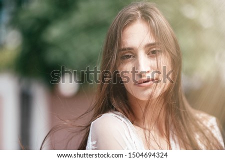 Young stylish girl having photoshoot outdoors. Copy space on the left side