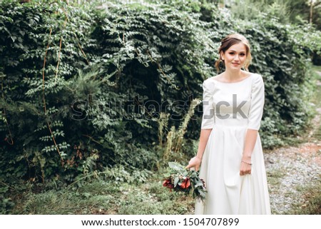 Portrait of a beautiful bride in a modest dress. Young brunette girl in a white dress with long sleeves. Cute bride with an autumn bouquet. Portrait of a woman outdoors on an autumn street. Royalty-Free Stock Photo #1504707899