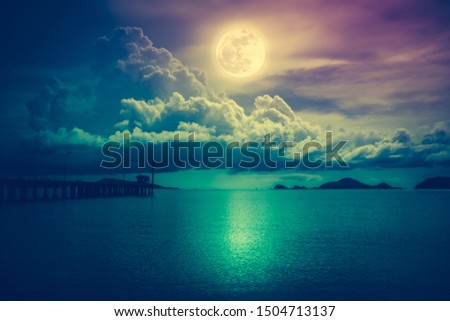 Beautiful landscape view of the sea. Colorful sky with clouds and bright full moon on seascape to night. Serenity nature background, outdoor at nighttime.