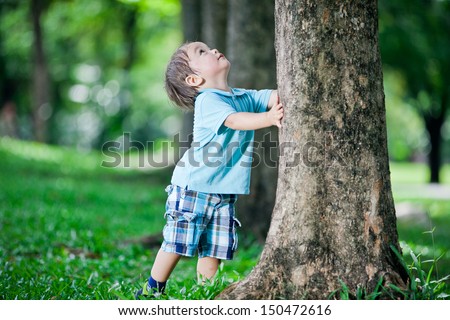 Boy playing at tree Royalty-Free Stock Photo #150472616