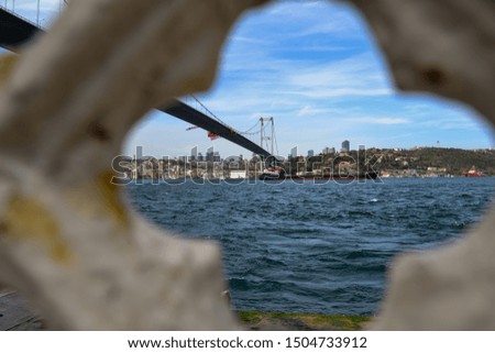 Panorama of Bosphorus Bridge with boats and the city skyline on European coast visible farther behind it. Istanbul, Turkey.
