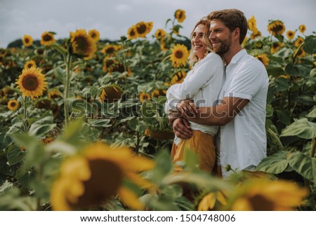 Handsome man hugging his wife outdoors in summer. Family relation concept