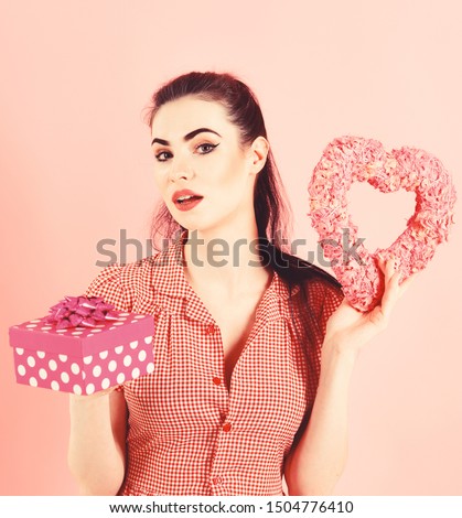 Surprise, relationship, Christmas, shopping, New Year, Black Friday concept. Girl with surprised face, make up and gift box. Woman in stylish dress holds present. Happy girl with symbol of love.