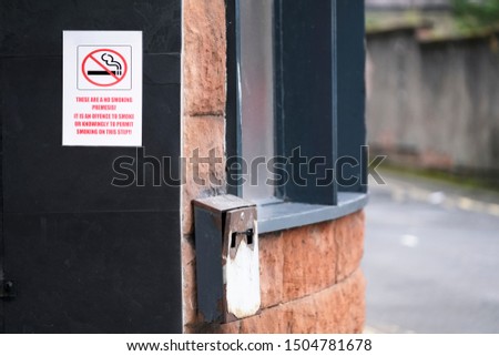 No smoking sign and metal ash tray outside pub 