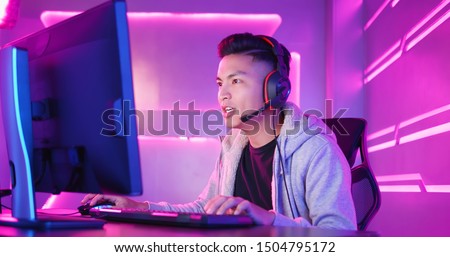 Young Asian Handsome Pro Gamer Playing in Online Video Game