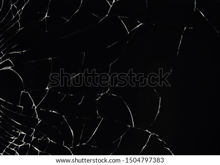 Texture of broken glass on a black background. Concept of broken automotive glass, screen phone, tablet, laptop. Flat lay, top view.