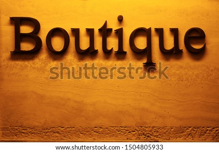 boutique wordon a golden concrete wall background.Concept of purchase and consumerism. night illumination