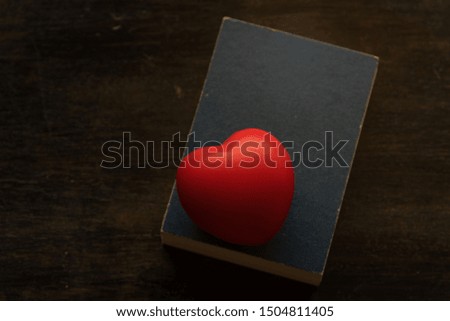 Red heart ball cartoon put on blue book,for good health or tell love in valentine day.
