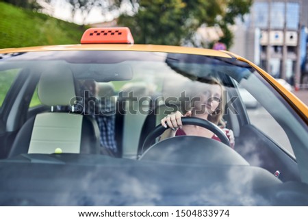 Photo through windshield of female driver on blurry background