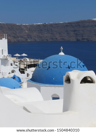 The famous blue domes on the cubiform whitewashed buildings, in the Greek Village of Oia on the Island of Santorini. Royalty-Free Stock Photo #1504840310