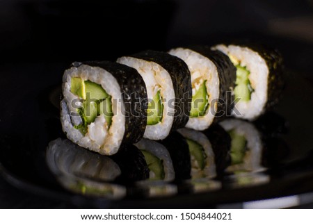 Sushi rolls with salmon and avocado on a dark background