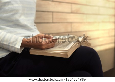 Woman enjoying reading a book. Education and reading concept
