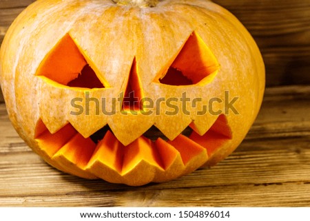 Spooky Halloween pumpkin jack-o-lantern on a wooden background