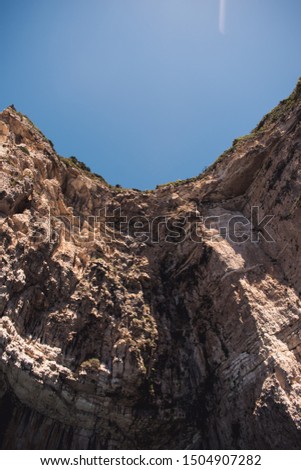 Cave in Greece, Corfu surrounded by sky blue water 