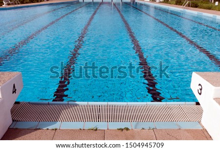 Starting blocks at the pool edge of a swimming pool. The blocks are number  three and four. The starting blocks are used for swimming competitions. Royalty-Free Stock Photo #1504945709