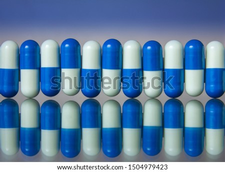 Row of pills on reflection glass