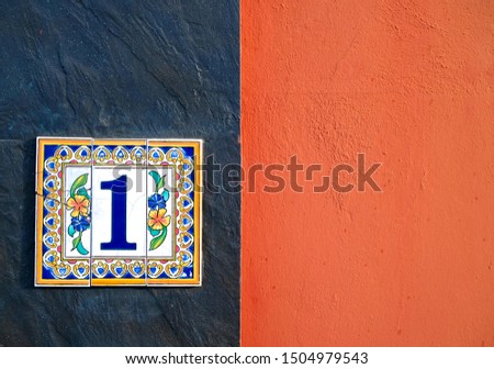 1, number one, decorative floral tile on a wall.