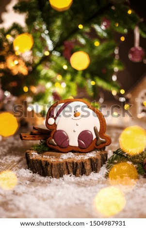 Holiday traditional food bakery. Gingerbread happy sitting Snowman or snowball in cozy warm decoration with garland lights.