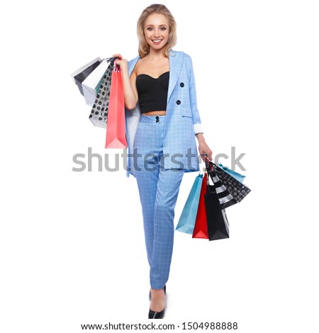 Beautiful girl with Hollywood locks, classic make-up in a elegant blue suit and shopping bags. Beauty face and body. Photo taken in studio on a white background.