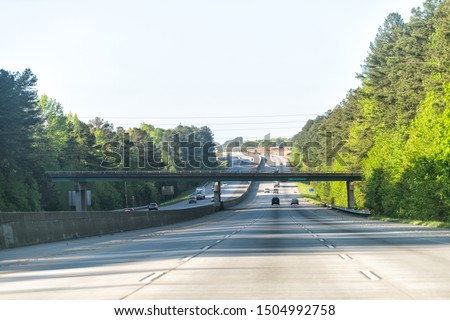 Interstate highway 85 road with overpass bridge exit sign road in early morning at city of Atlanta, Georgia with cars driving on commute Royalty-Free Stock Photo #1504992758