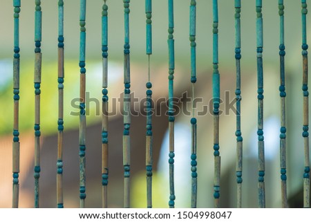 Selective focus close up of blue and green wooden beads on strings 