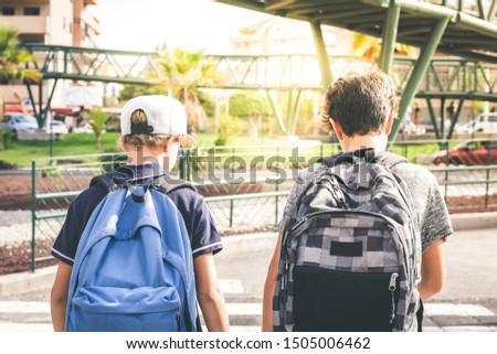 Sad young boys walking in the city, going to the college for the first day of school. Teenagers with backpack walks in urban contest. Back to secondary school. Education, lifestyle, youth, concept.
