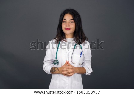 Business Concept - Portrait beautiful doctor woman holding hands with confident face isolated over gray Background.