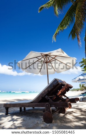 Sun umbrella and sunlongers on sandy tropical beach with white sand and turquoise sea water. Travel destinations. Summer vacations Royalty-Free Stock Photo #1505081465