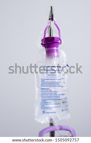 Feeding Pump medical device purple color to supplement nutrition liquid food to tube Enteral feeding fluid set bag with clamp hanging on stand. Royalty-Free Stock Photo #1505092757
