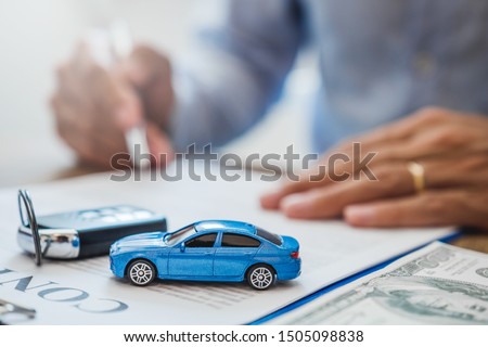Sale agent  deal to agreement successful car loan contract with customer and sign agreement contract  Insurance car concept.