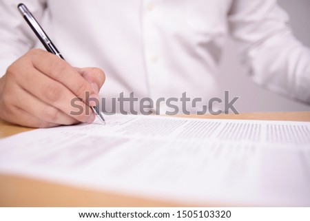 Close up image of businessman signing contract or student having exam test, selective focus