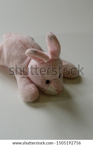 Selective focus on small pink rabbit soft toy isolated on white background
