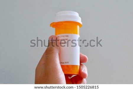 Hand holding medicine bottle in white background 