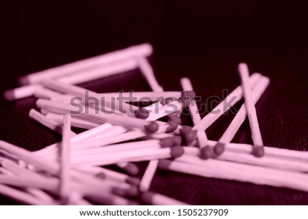 Scattered matches on dark background close up. Pink color toned