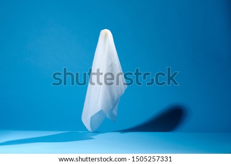Picture of halloween ghosts from white fabric on blue background