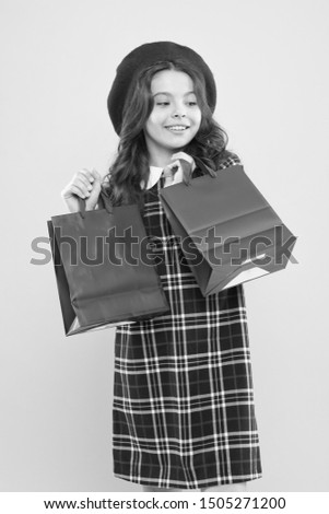 discount. little girl in french style hat. happy girl with long hair in beret. little beauty shopaholic. Holiday present. shopping. child with shopping bag. parisian child on yellow. discount concept.
