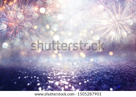 abstract gold, purple and blue glitter background with fireworks. christmas eve, 4th of july holiday concept