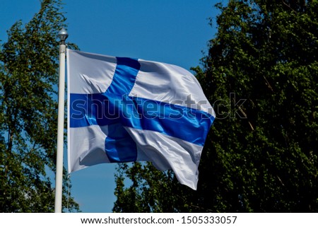 Finlands blue white flag waving in the wind on a sunny day