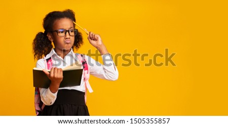 Puzzled African American School Girl Thinking Scratching Head With Pencil Holding Textbook On Yellow Background. Empty Space, Panorama